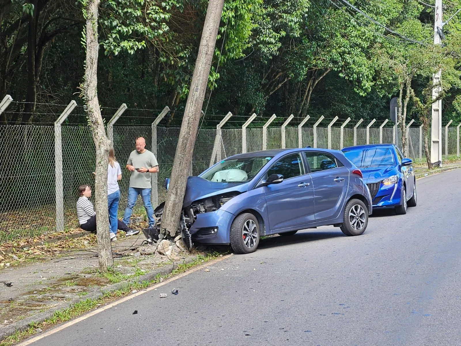 Batida forte deixa poste pendurado e motorista ferida no Bacacheri