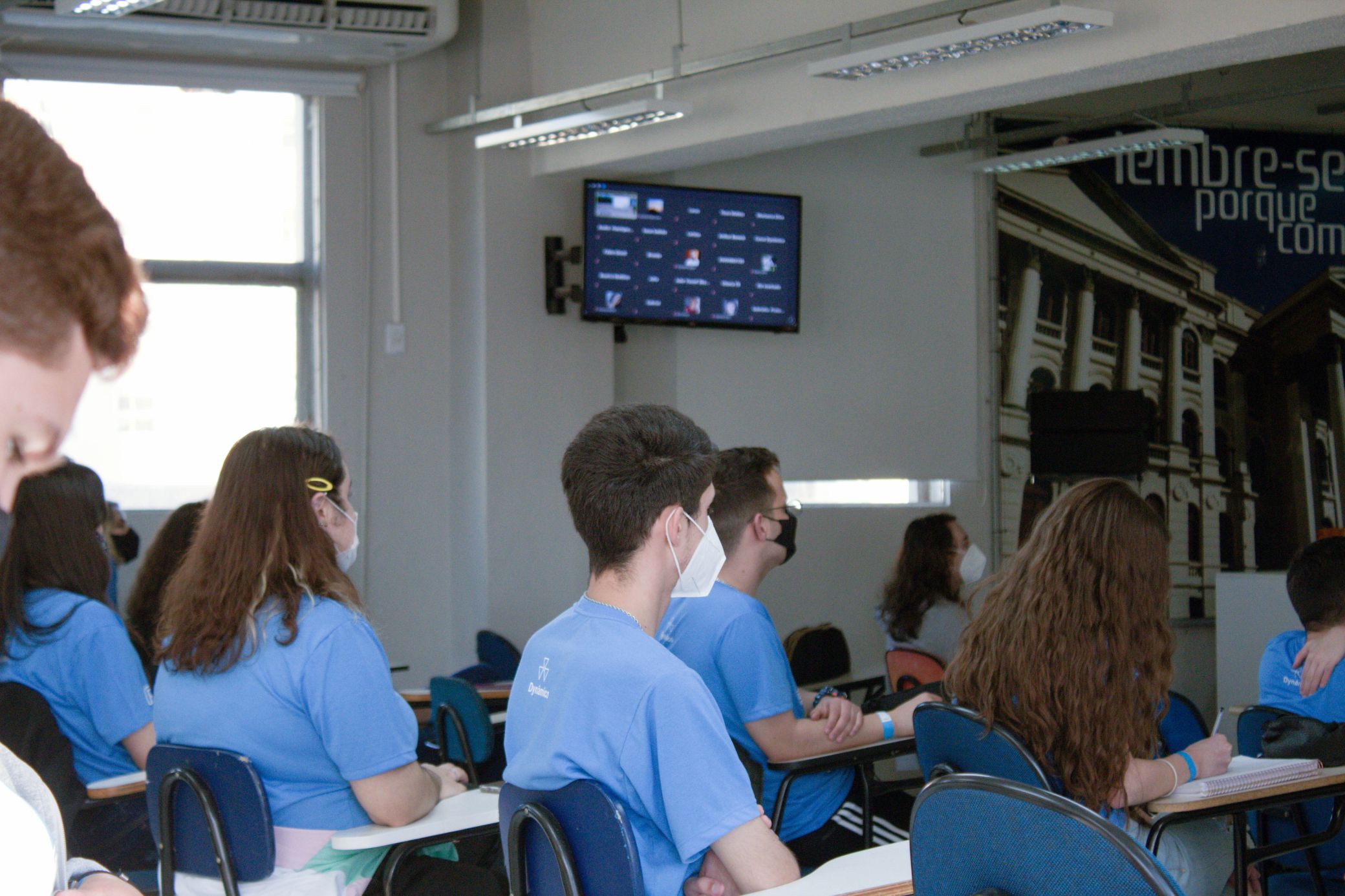 Em todas as salas de aula do Dynâmico existe uma TV onde aparecem as perguntas e interações dos alunos que assistem à aula em casa. | Foto: Divulgação