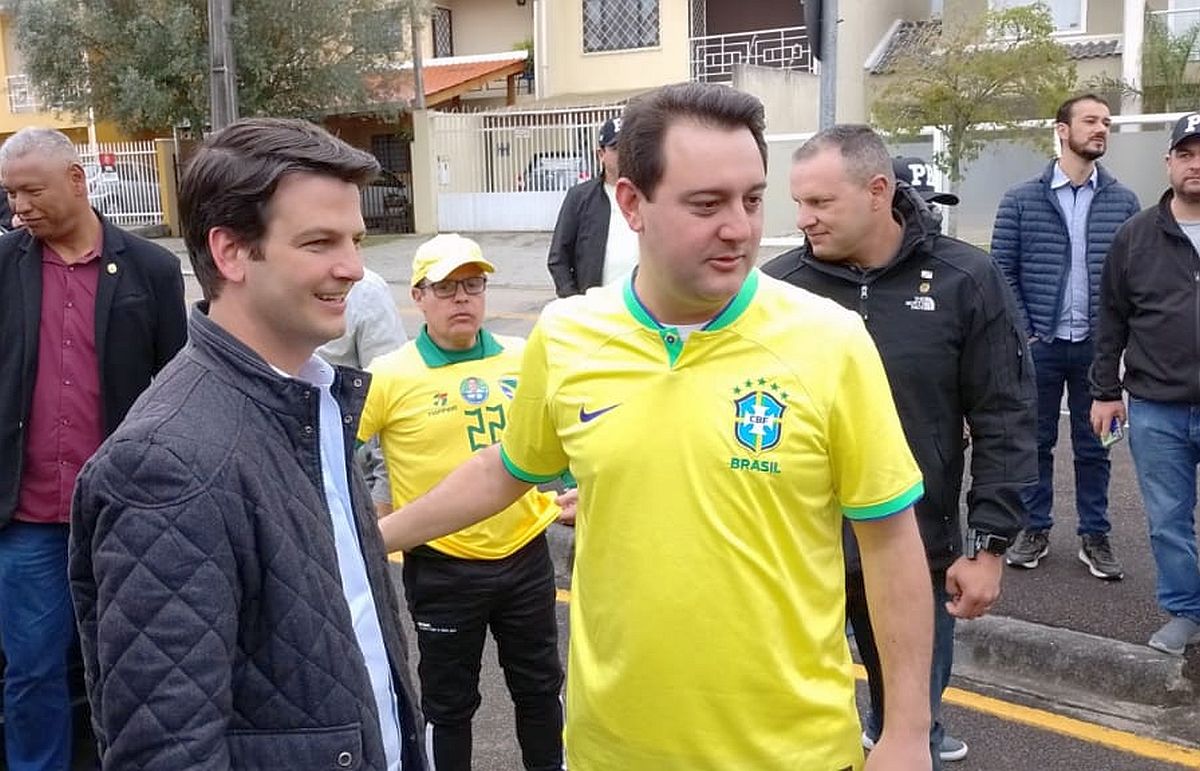 Governador do Paraná em primeiro plano, ao lado do vice prefeito de Curitiba, com a camisa da seleção brasileira