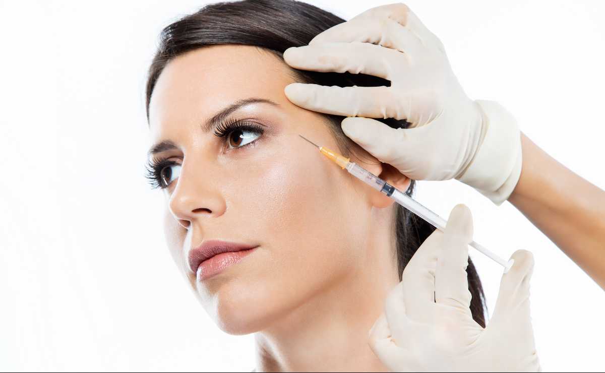 Mulher aplica botox em pacientes na região em volta dos olhos.