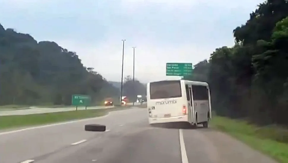 Imagem mostra o ônibus no meio da rodovia, com a roda caída ao seu lado