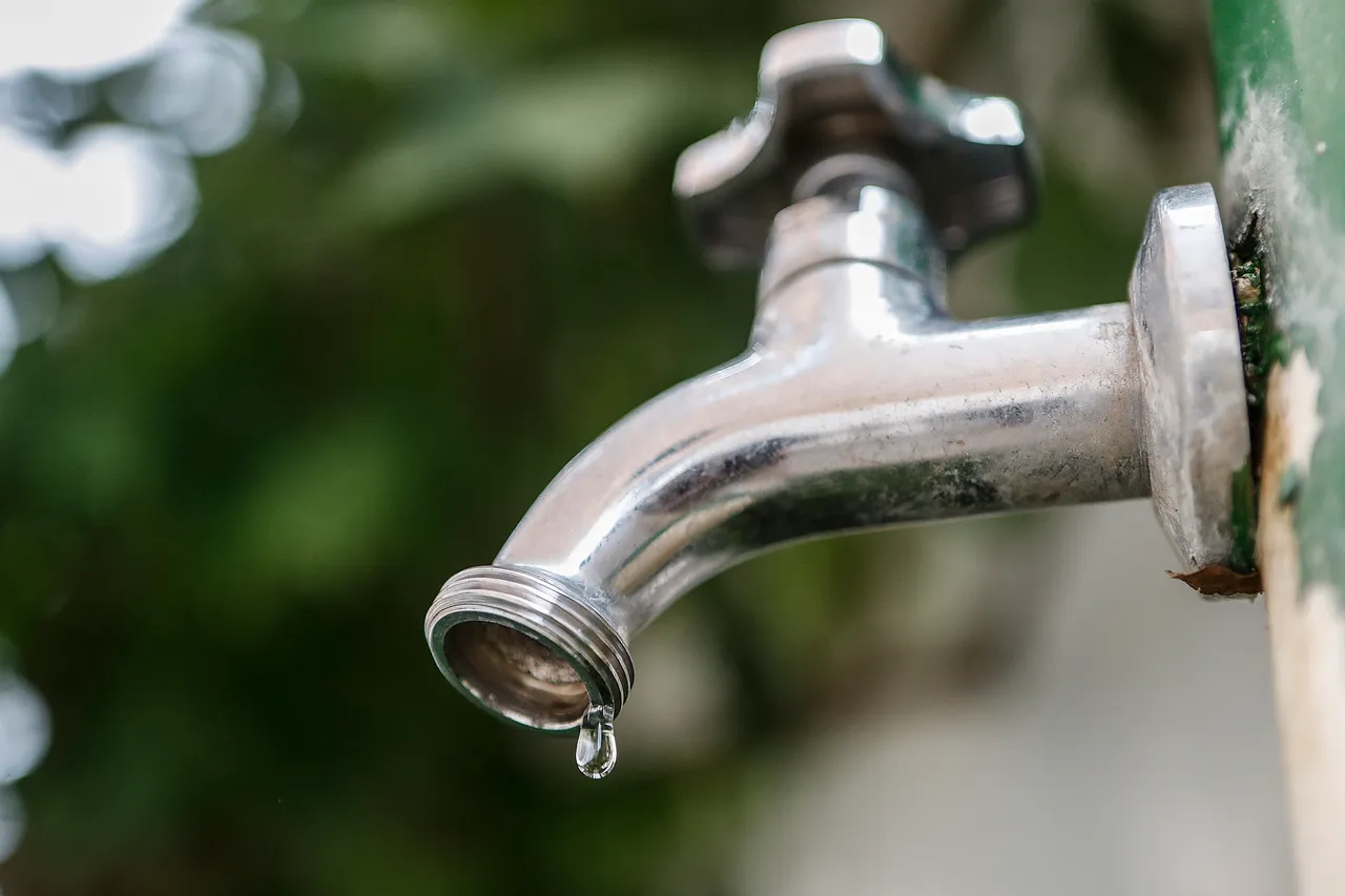 Torneira fechada, com uma gota de água.