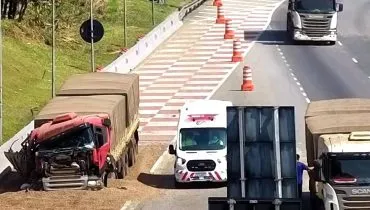 Imagem aérea mostra uma caminhão vermelho com a frente destruída em uma área de escape da BR-277. Há uma ambulância e vários cones isolado a área.