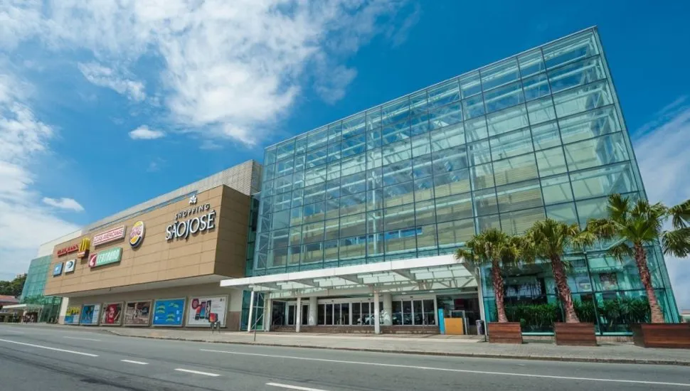 Fachada do Shopping São José, em dia de sol e céu com nuvens.