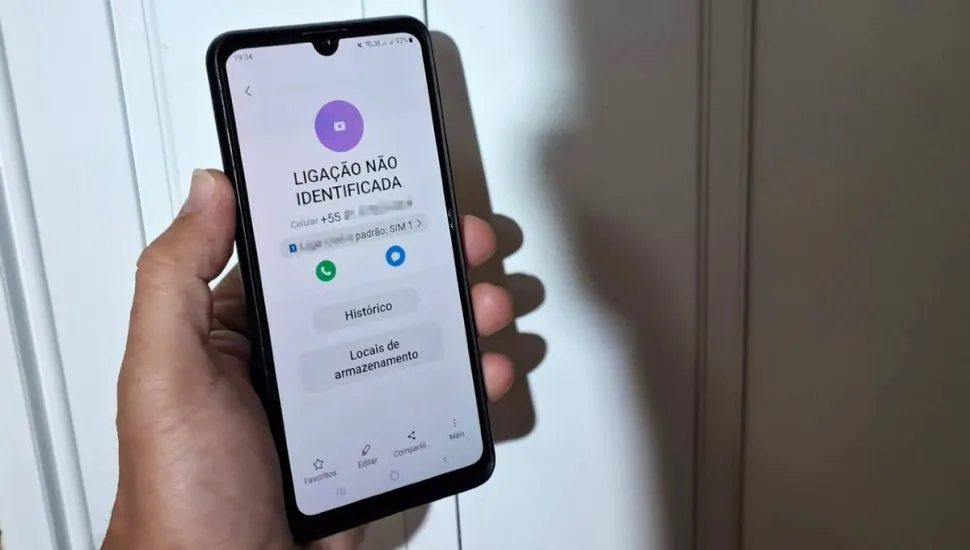 Na imagem, um telefone celular com "ligação não identificada" na tela.