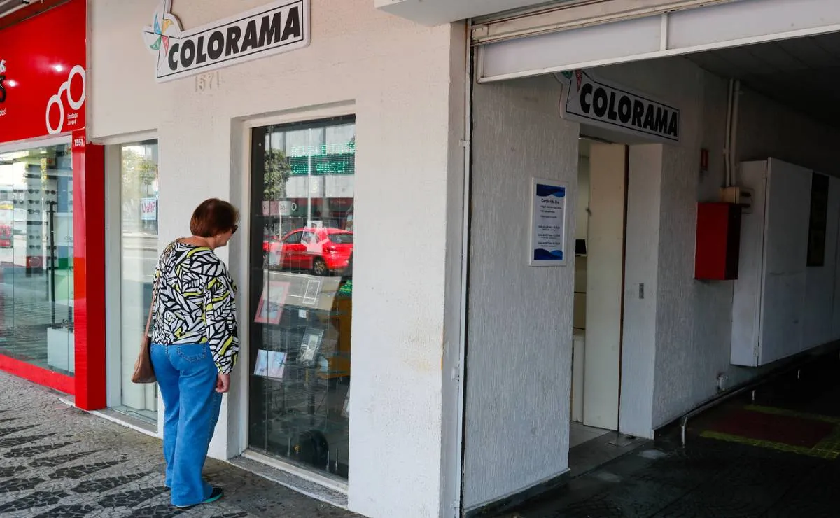 Imagem mostra a fachada de uma empresa em Curitiba com uma mulher olhando a vitrine.