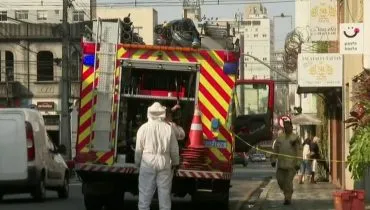 Caminhão do Corpo de Bombeiros, com bombeiros de roupas especiais para retirada de abelhas.