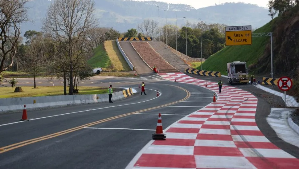 imagem mostra trecho da rodovia com a nova área de escape, com vários trabalhadores finalizando a obra