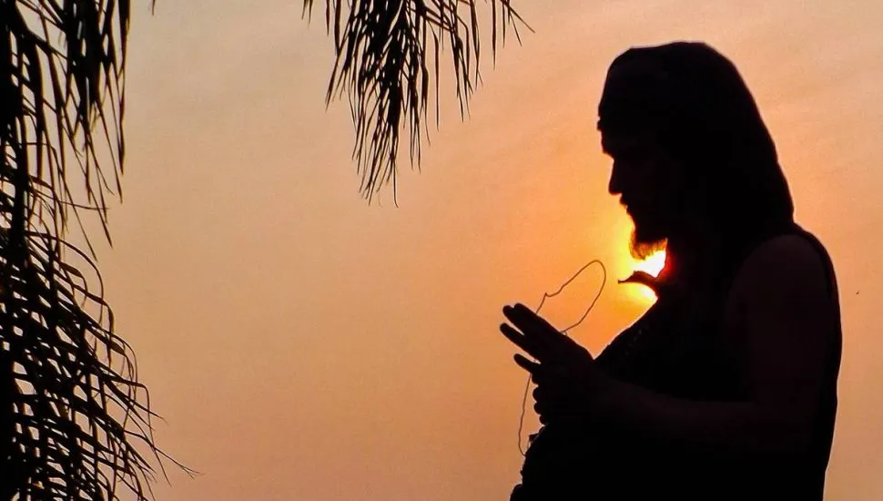 Imagem mostra a silhueta de um homem com um sol escaldante ao fundo.