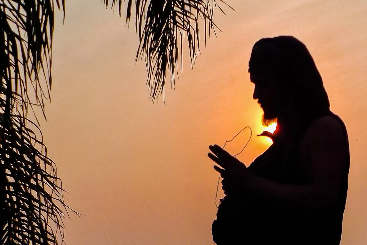 Imagem mostra a silhueta de um homem com um sol escaldante ao fundo.