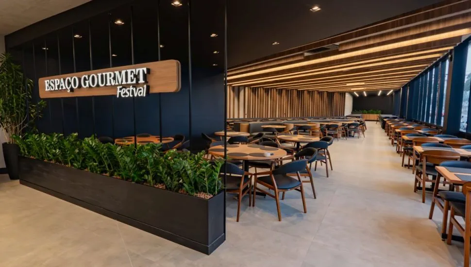 Imagem mostra a entrada do espaço do restaurante, com mesas e cadeiras ao fundo