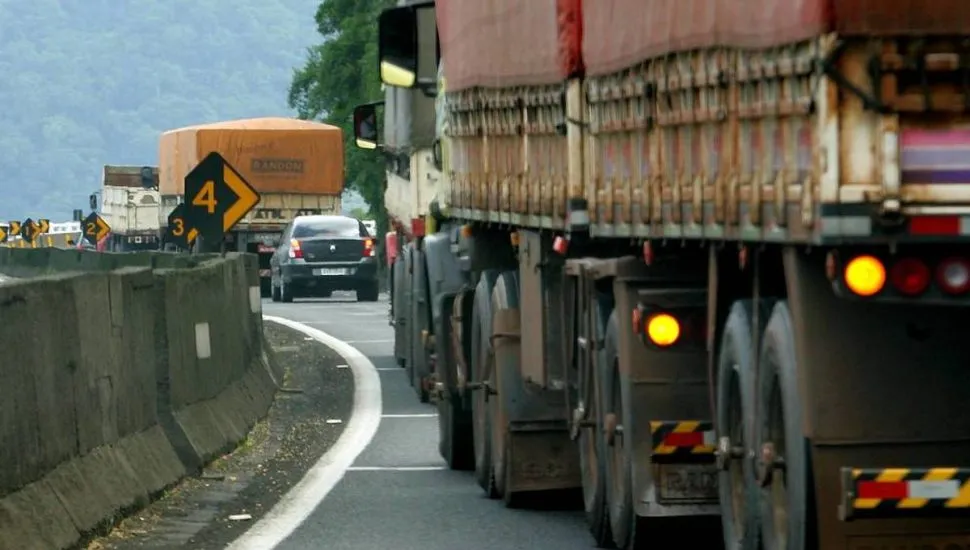 Imagem mostra um caminhão trafegando pela BR-277 com o pisca ligado.