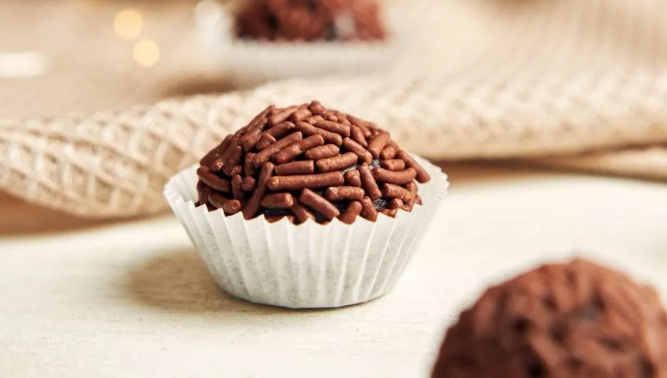 Imagem mostra um brigadeiro em cima de uma mesa.