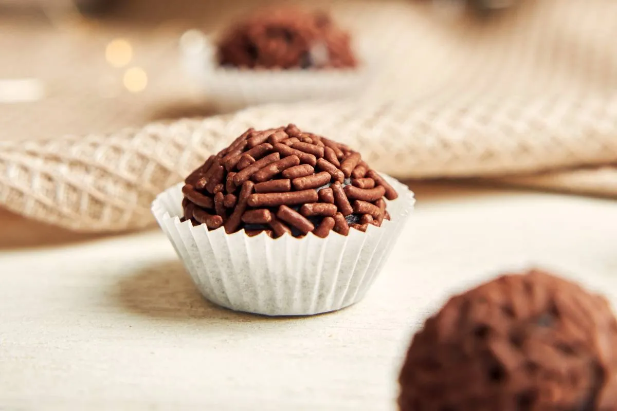 Imagem mostra um brigadeiro em cima de uma mesa.