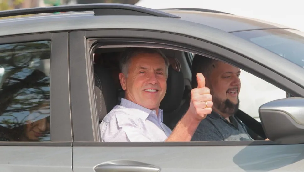 Luizão Goulart acenando de dentro do carro.