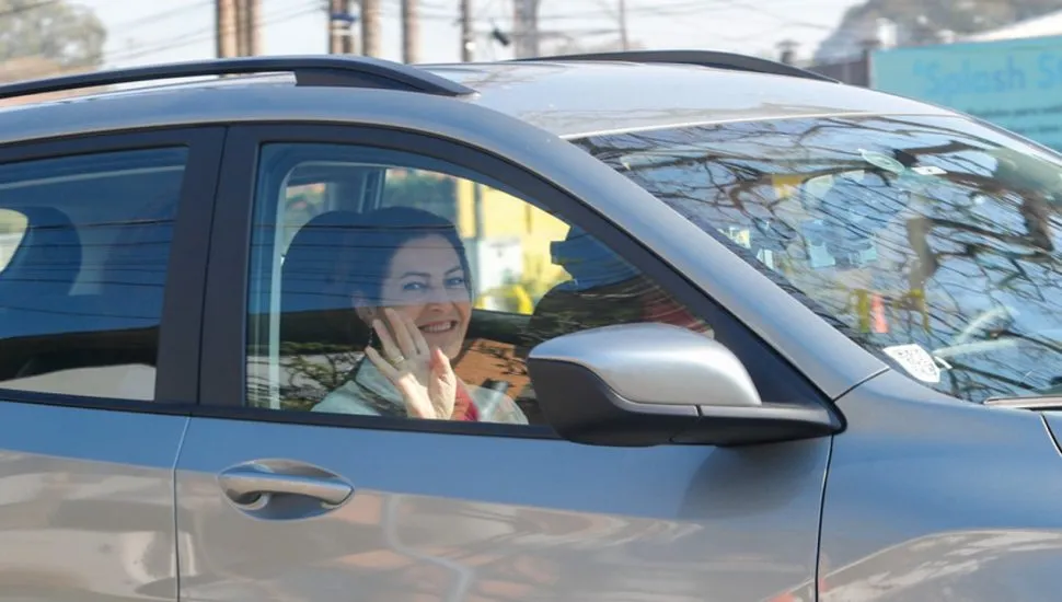 Cristina Graeml acena de dentro do carro.