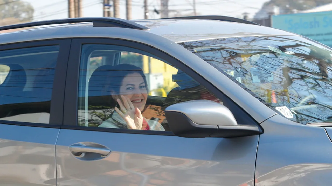 Cristina Graeml acena de dentro do carro.