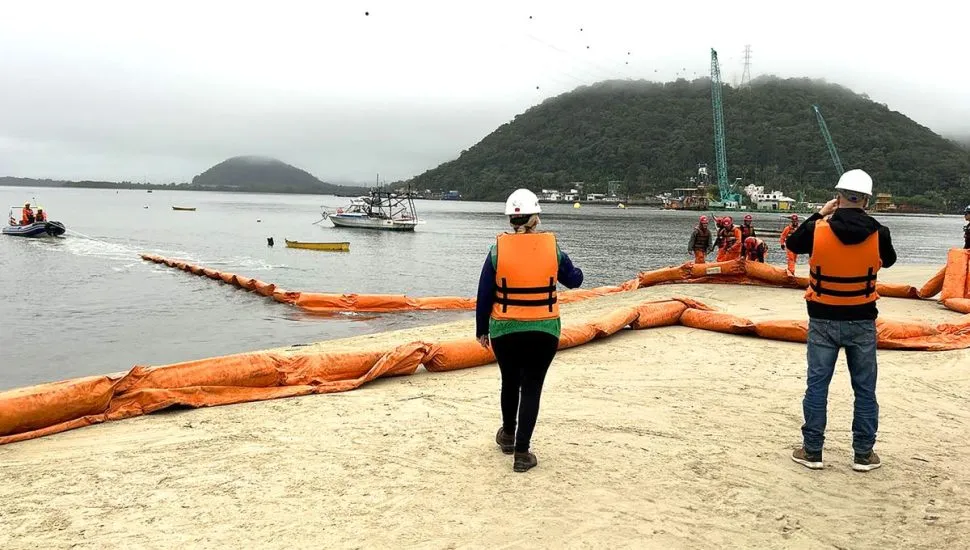 Na imagem, profissionais na areia e no mar instalam equipamentos usados em emergências marítimas.