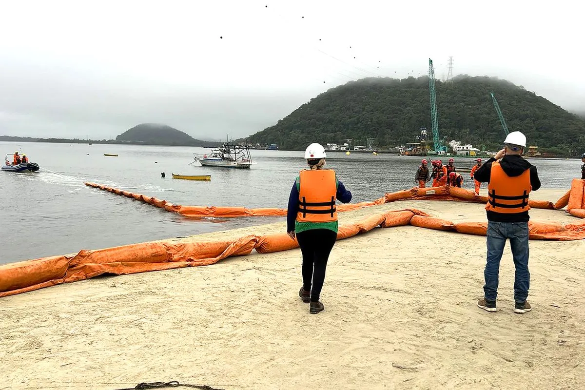 Na imagem, profissionais na areia e no mar instalam equipamentos usados em emergências marítimas.