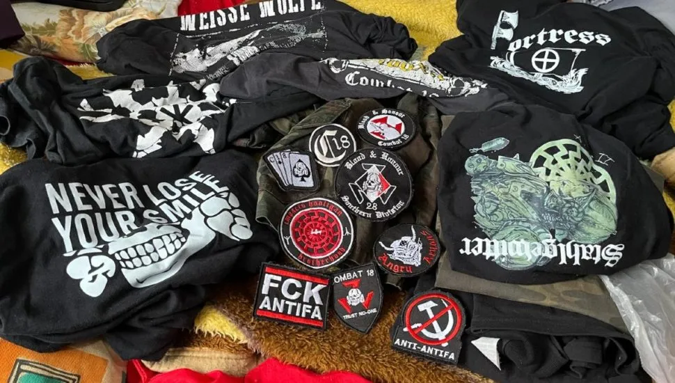 Na imagem, camisetas e outros itens com símbolos neonazistas, apreendidos pela polícia.