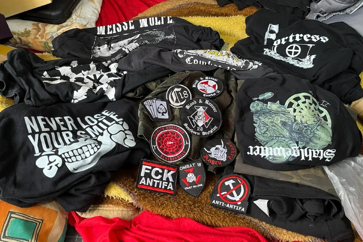 Na imagem, camisetas e outros itens com símbolos neonazistas, apreendidos pela polícia.