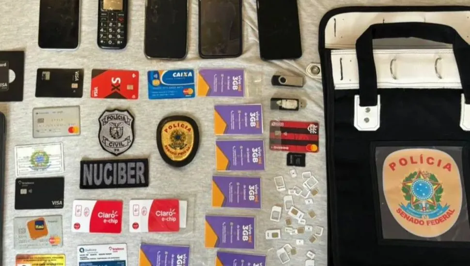 Imagem mostra cartões e celulares dispostos em uma bancada da Polícia Civil.