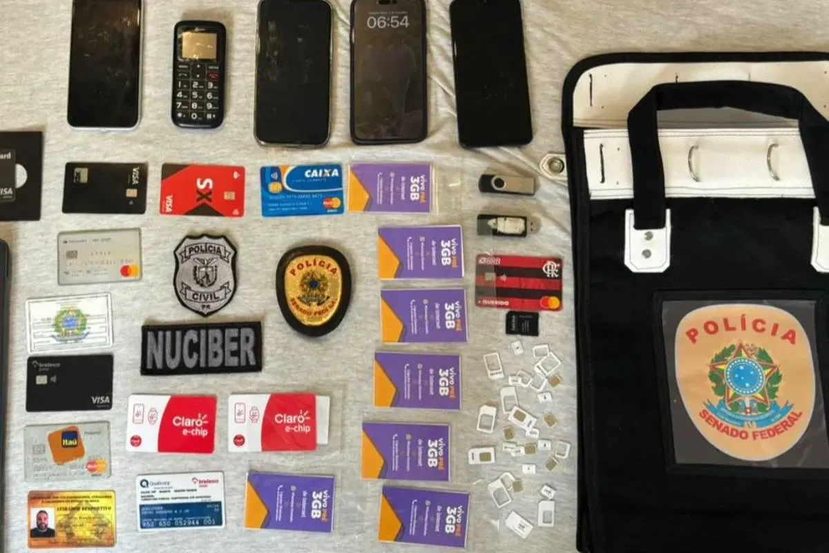 Imagem mostra cartões e celulares dispostos em uma bancada da Polícia Civil.