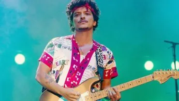 Na imagem, cantor Bruno Mars toca guitarra em show