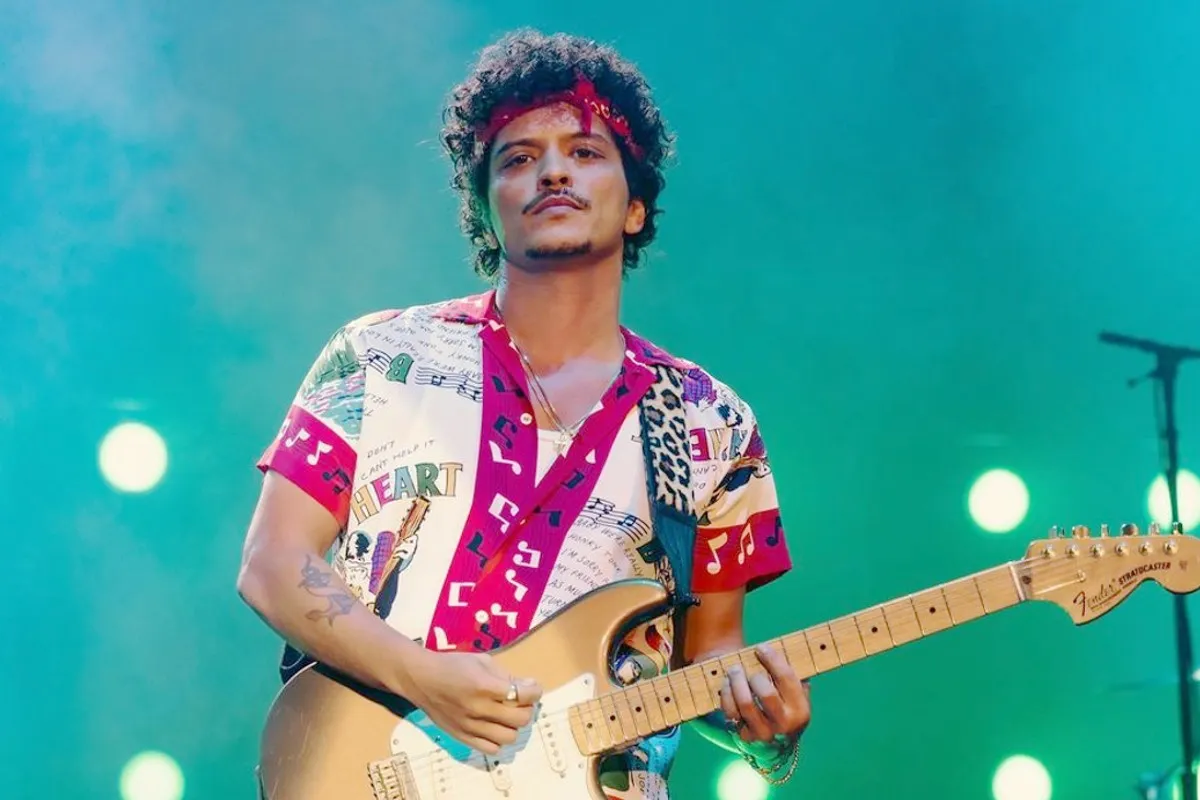 Na imagem, cantor Bruno Mars toca guitarra em show