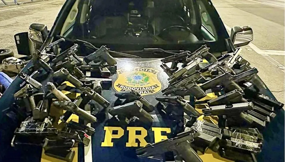 Na imagem, diversas pistolas e carregadores sobre o capô de uma viatura da PRF.