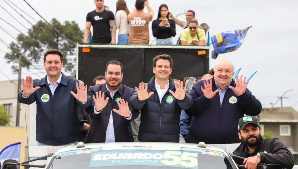 Na imagem, Ratinho Junior, Paulo Martins, Eduardo Pimentel e Rafael Greca, em cima de um carro, em campanha na rua.