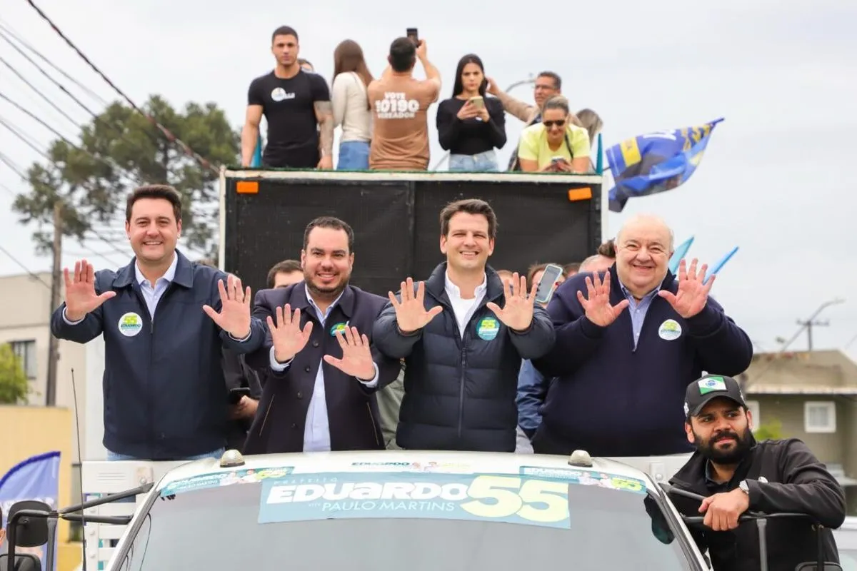 Na imagem, Ratinho Junior, Paulo Martins, Eduardo Pimentel e Rafael Greca, em cima de um carro, em campanha na rua.