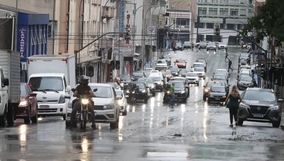 Imagem mostra um dia de chuva em Curitiba com carros andando no asfalto molhado