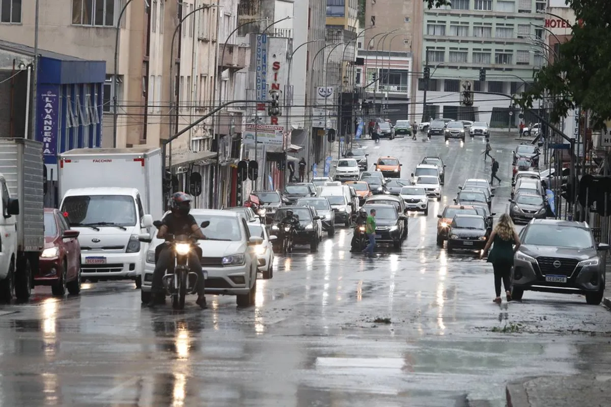 Imagem mostra um dia de chuva em Curitiba com carros andando no asfalto molhado