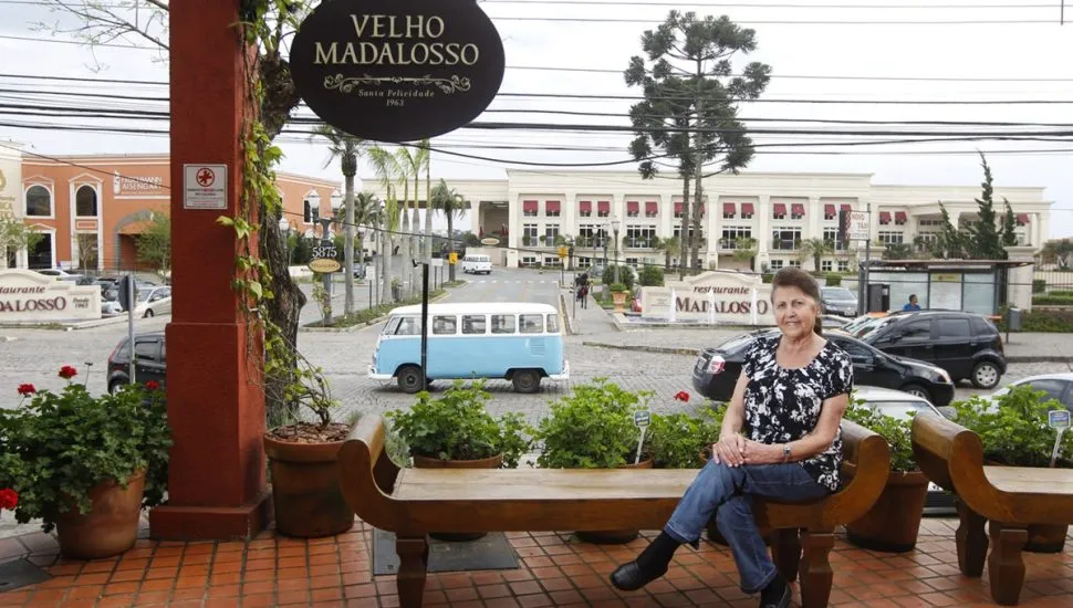 Flora Madalosso sentada em banco do Restaurante Madalosso, em Curitiba