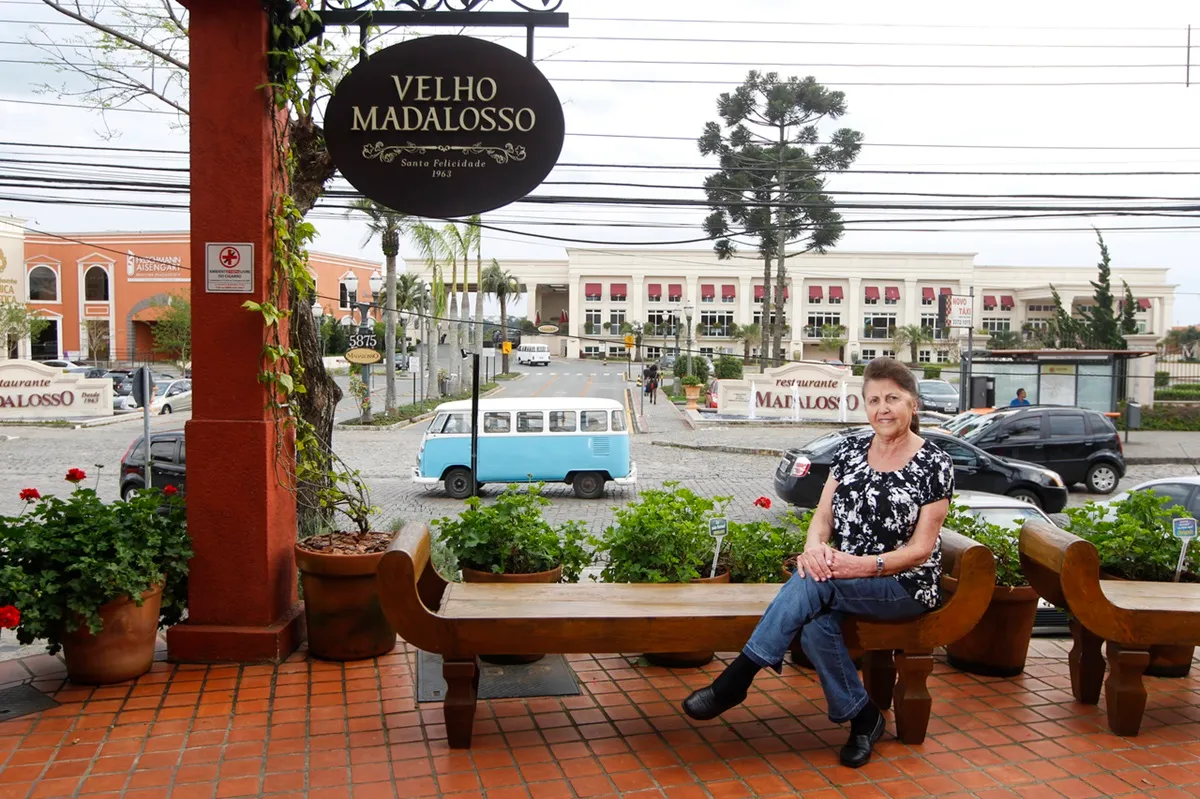 Flora Madalosso sentada em banco do Restaurante Madalosso, em Curitiba