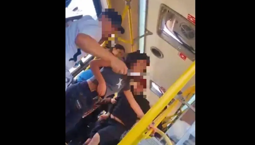 Imagem mostra um print do vídeo de uma briga dentro de um Ônibus de Curitiba.