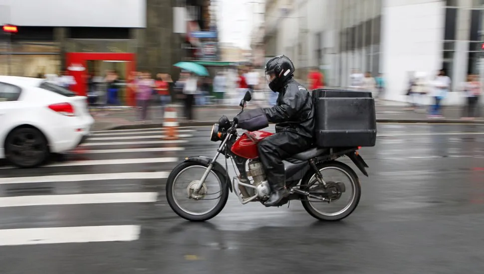 imagem mostra motoqueiro no centro de Curitiba durante um dia de chuva