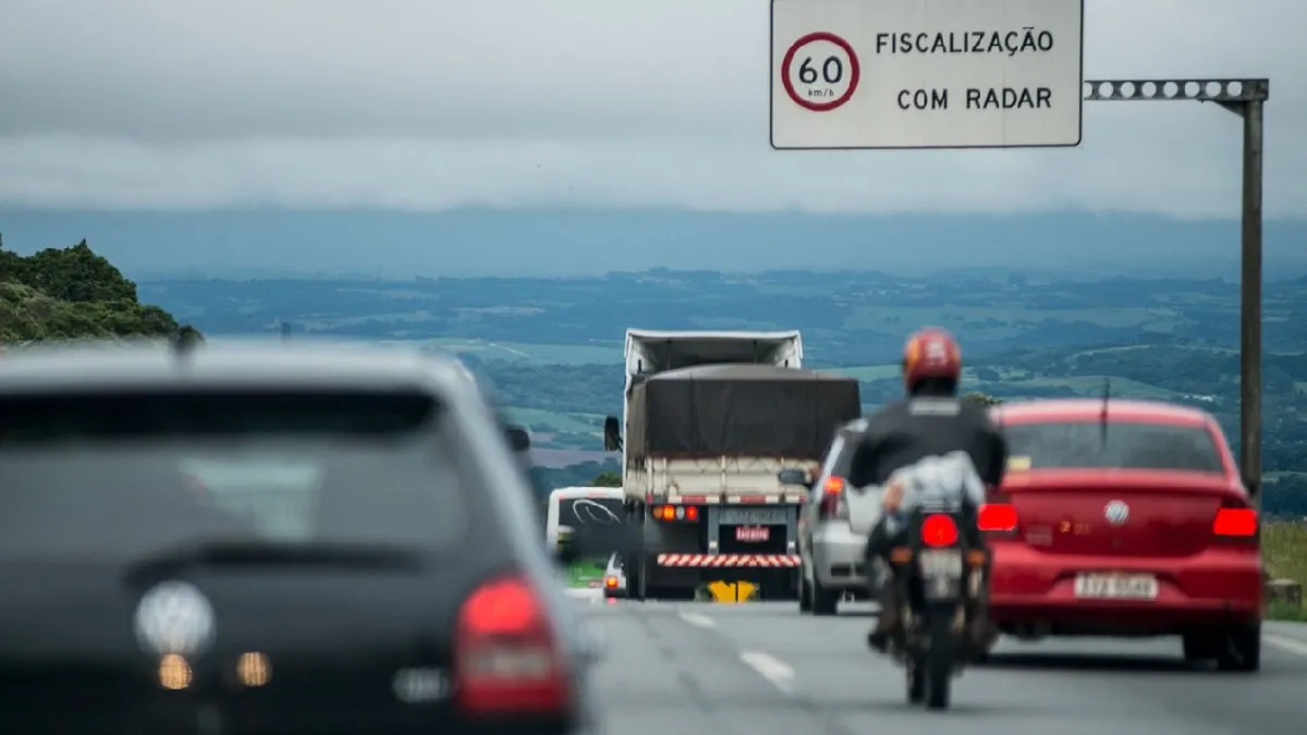 Na imagem, placa em rodovia indica fiscalização com radar, com limite de velocidade de 60 km/h.