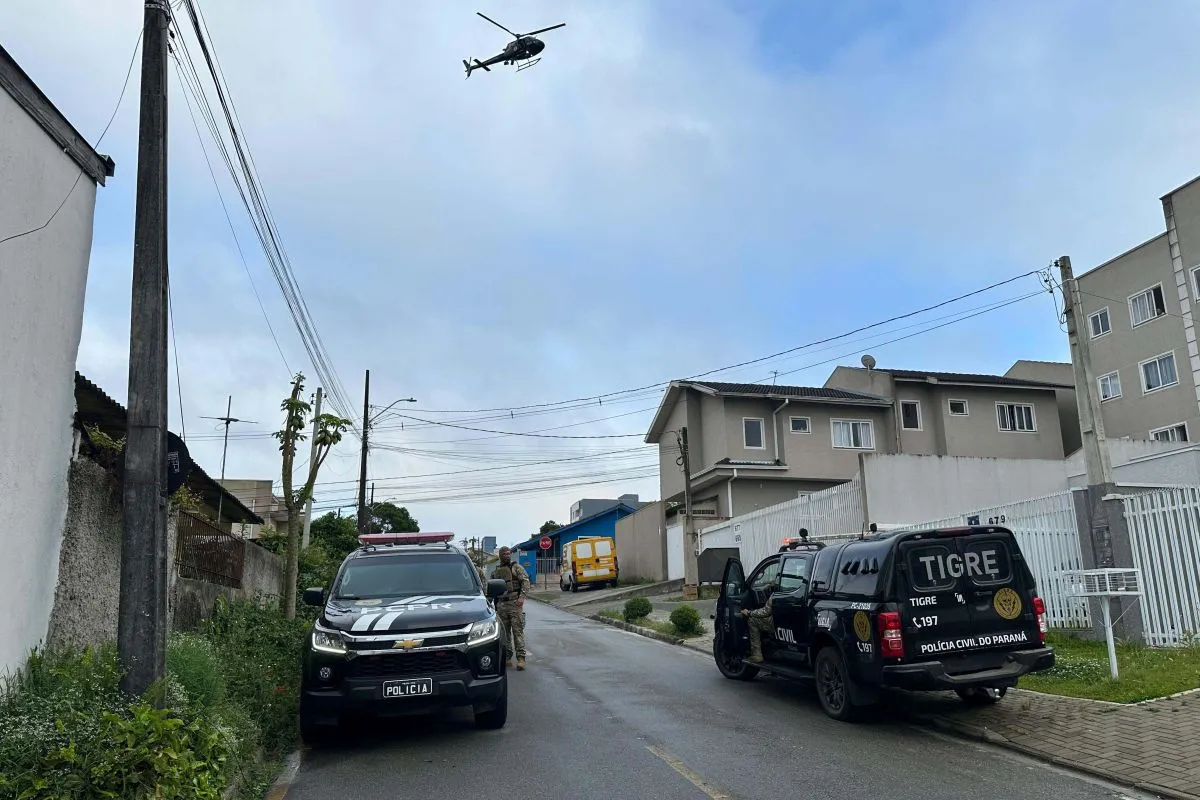 Na imagem, helicóptero e viaturas da polícia civil na rua.