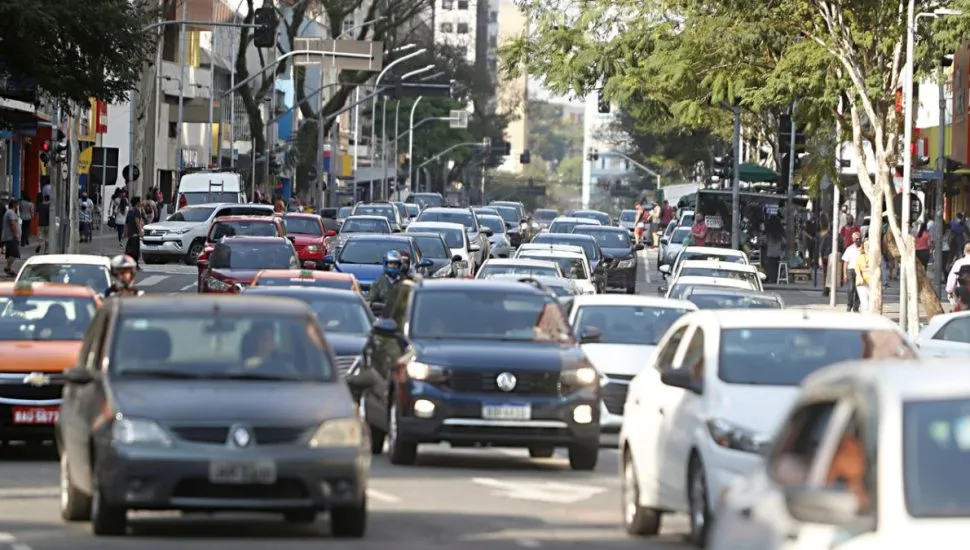 Na imagem, carros e motos no trânsito de Curitiba.