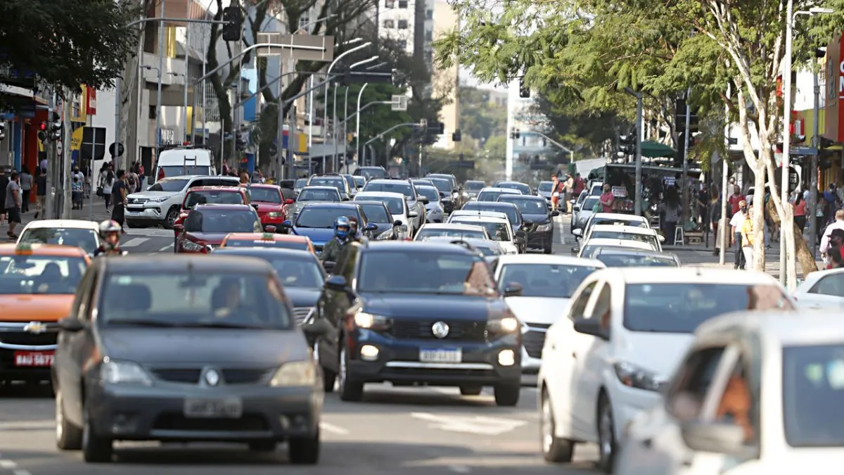 Na imagem, carros e motos no trânsito de Curitiba.