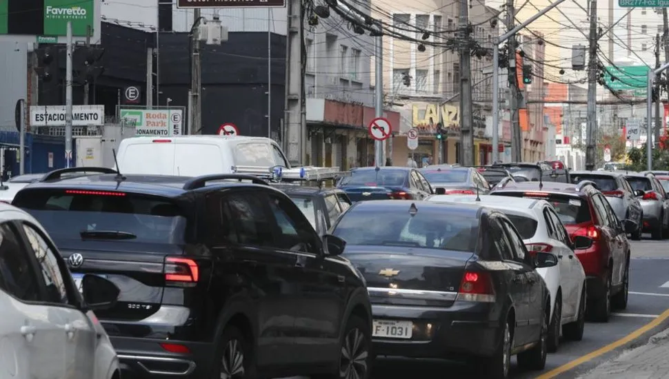 Imagem mostra o transito em Curitiba em um dia de semana. Carros estão em um congestionamento.