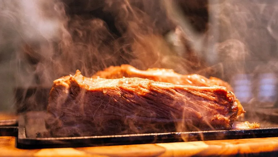 Imagem mostra pedaço de costela saindo fumaça feita em forno especial