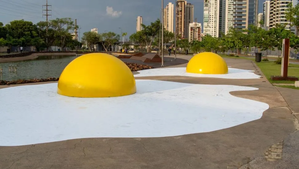 Imagem mostra uma praça, com duas esculturas em forma de ovos fritos, com prédios da cidade de Belém ao fundo