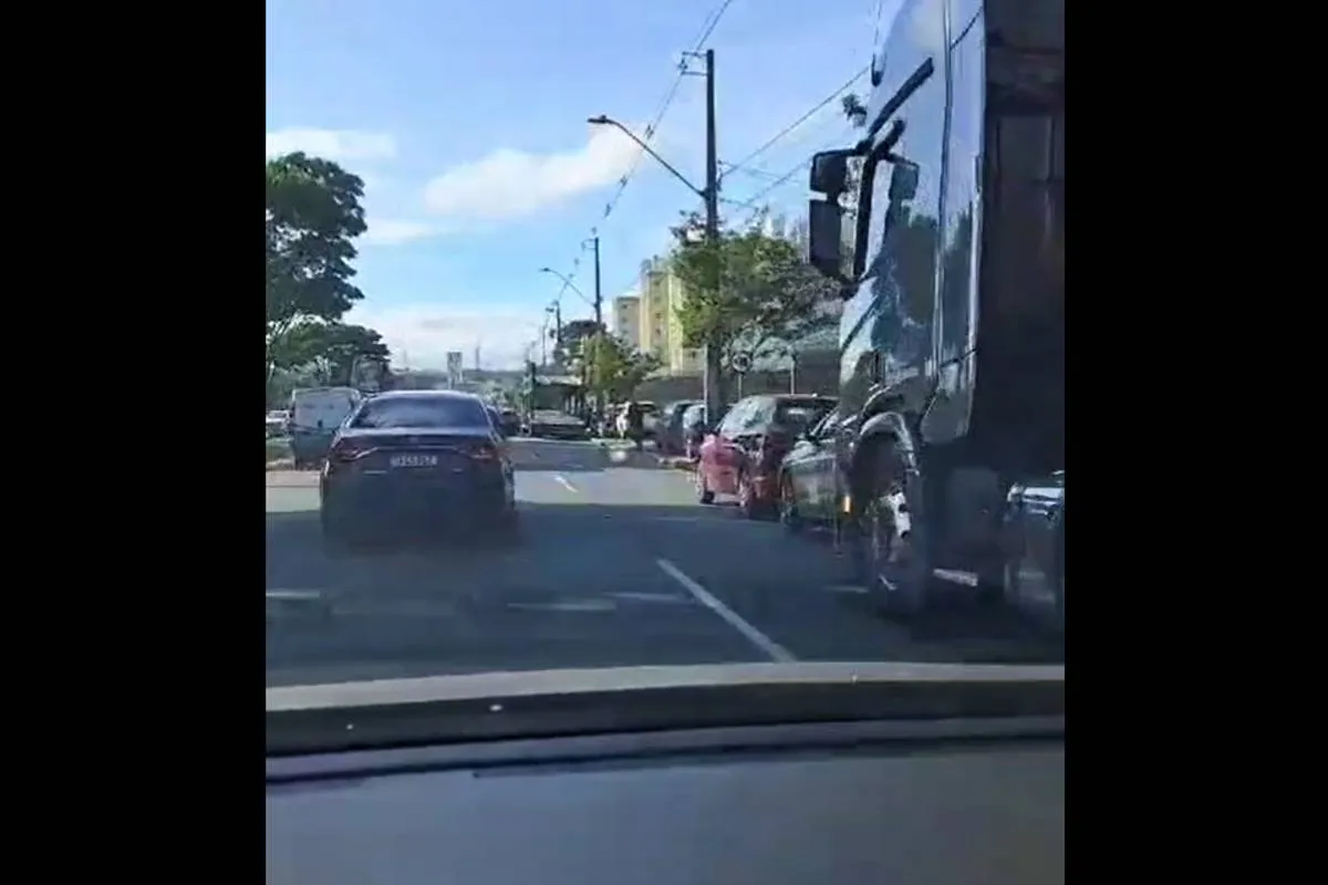 Duas cegonheiras travavam uma das faixas da Avenida das Torres em horário de pico. Há carros sendo descarregados na calçada e ocupando a própria faixa da avenid