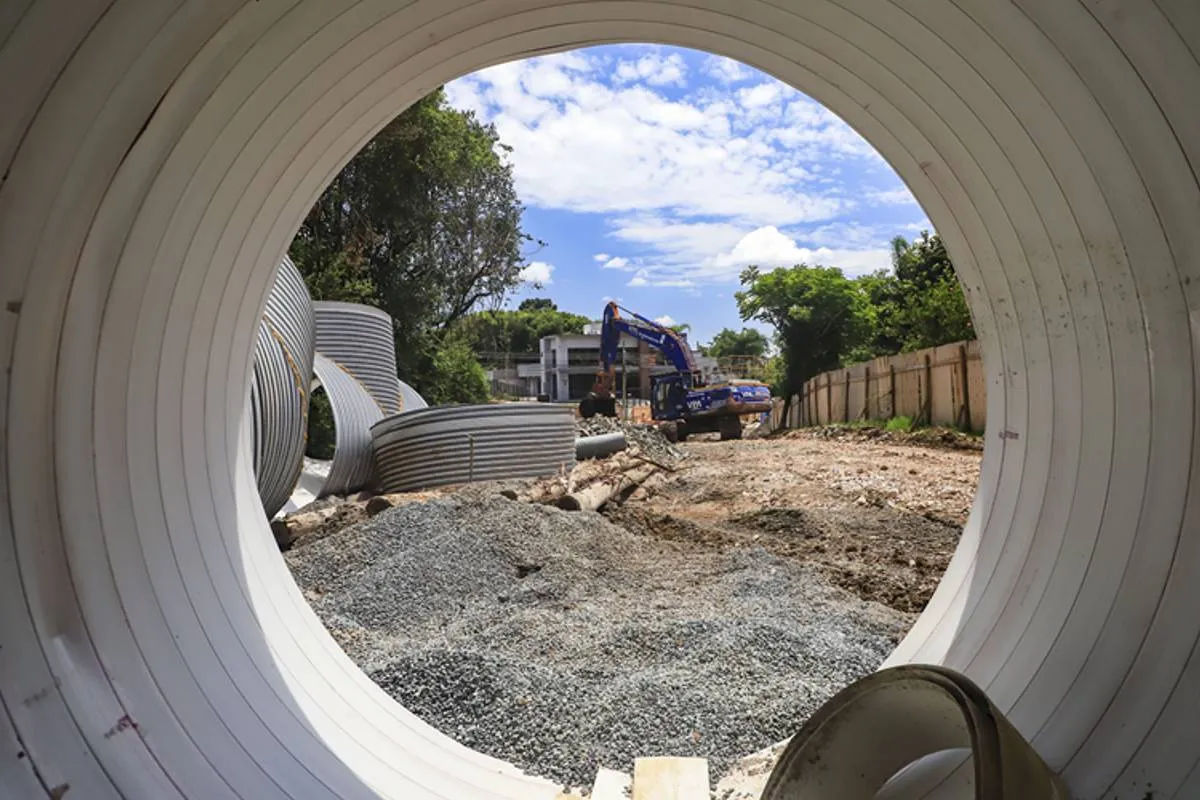 Imagem mostra uma obra em Curitiba com máquinas escavadeiras, buracos e manilhas gigantes.