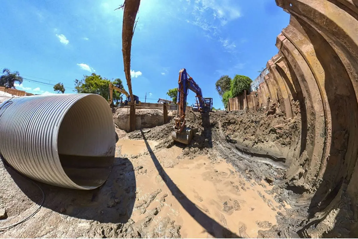 Imagem mostra uma obra em Curitiba com máquinas escavadeiras, buracos e manilhas gigantes.