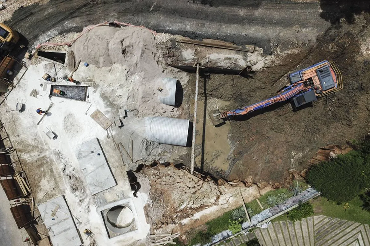 Imagem mostra uma obra em Curitiba com máquinas escavadeiras, buracos e manilhas gigantes.