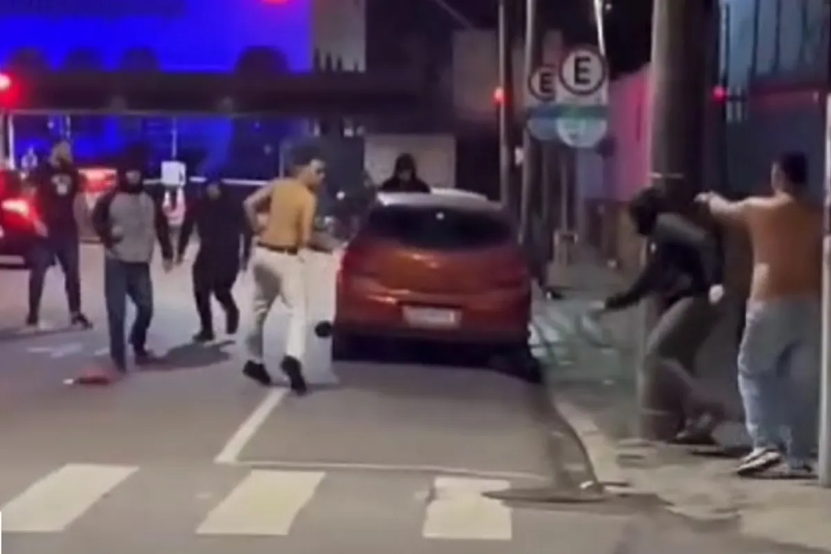 Na imagem, homens brigam em uma rua de Curitiba